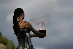 Under a cloud, the Olympic flame begins its journey to the Milan Cortina Winter Olympics